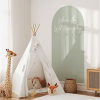 White teepee-style play tent with decorative pom poms.